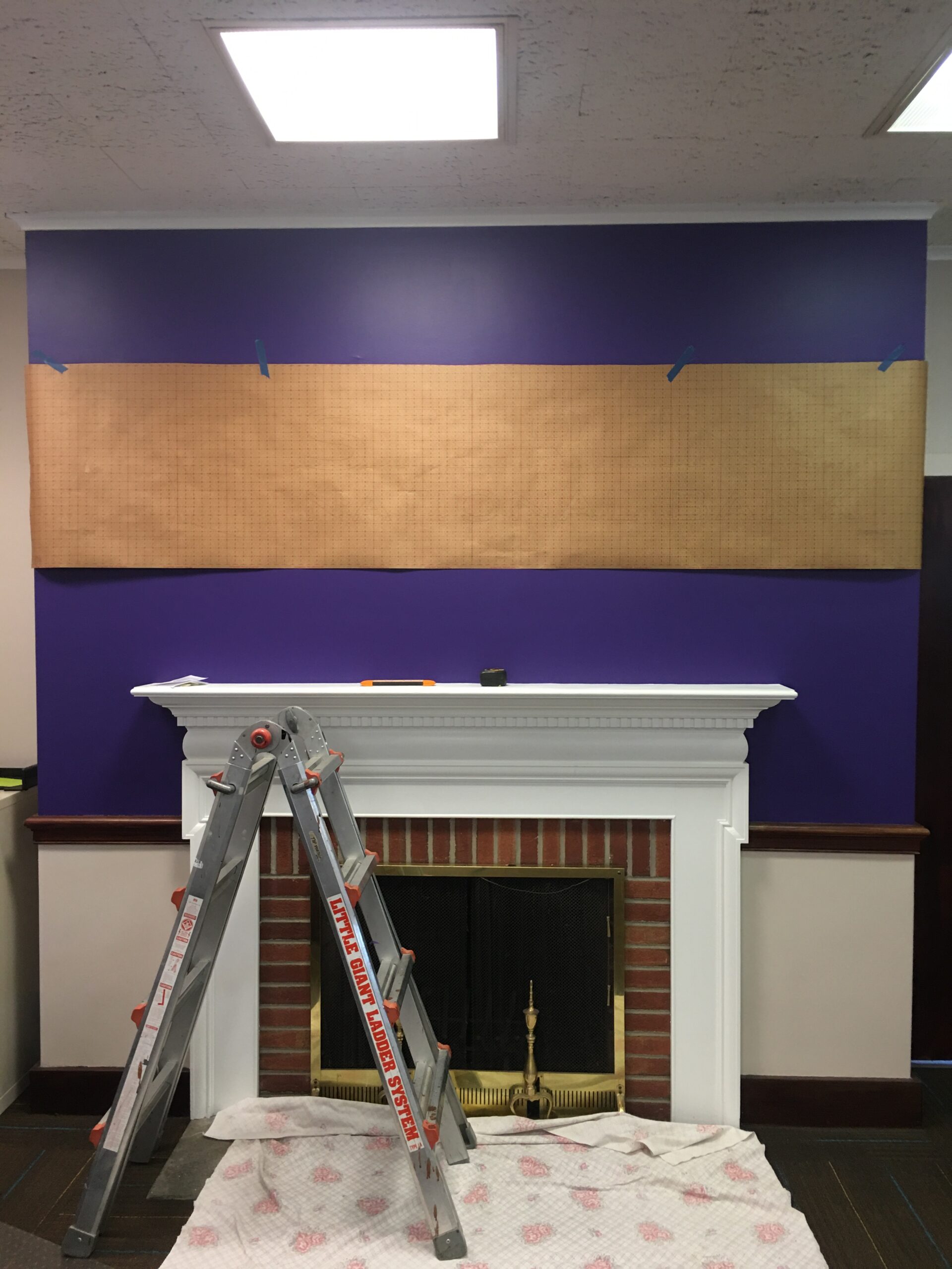 Ladder in front of fireplace installing signage
