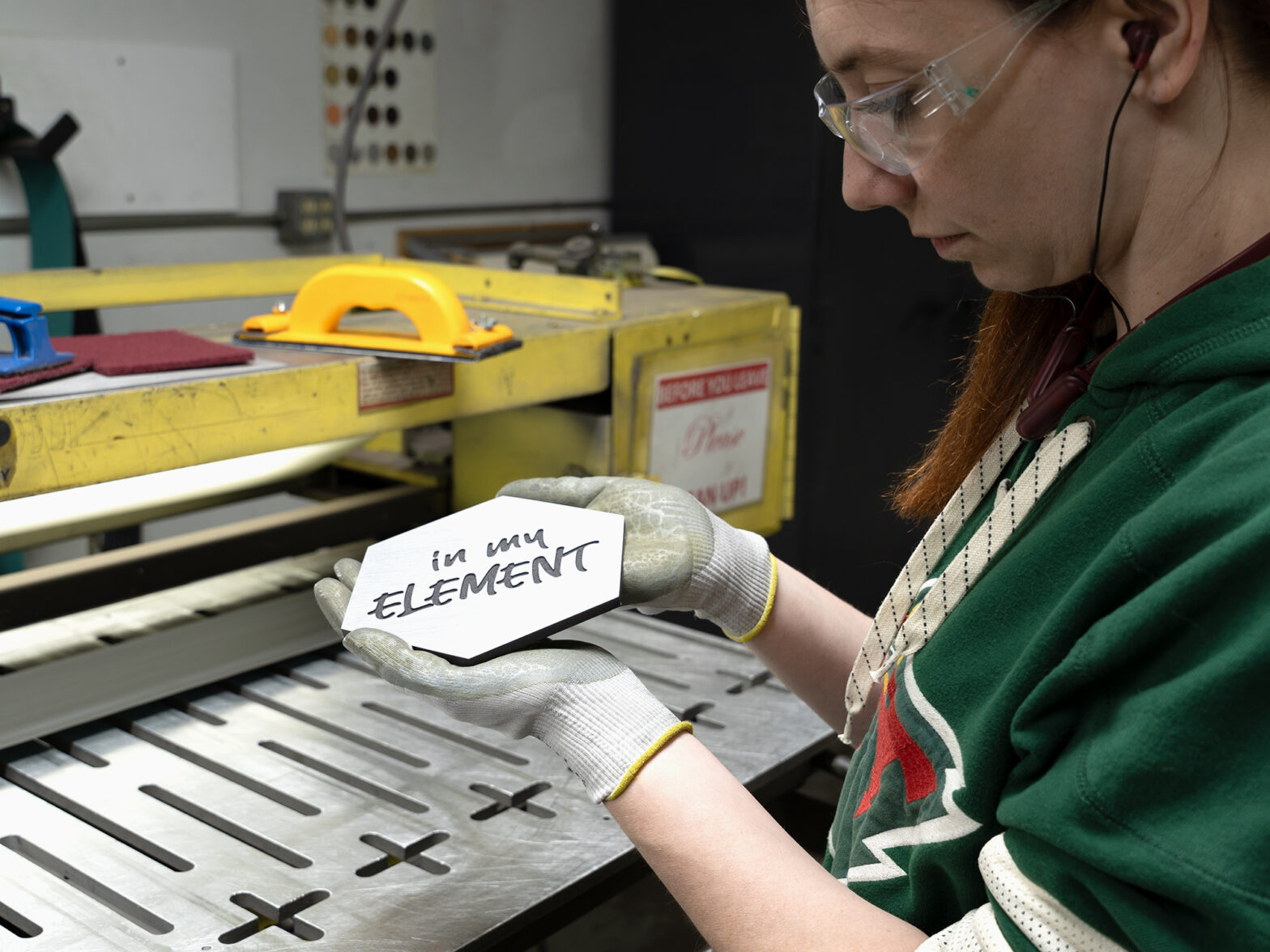 Woman holding a silver brushed plaque. Communicating sign design